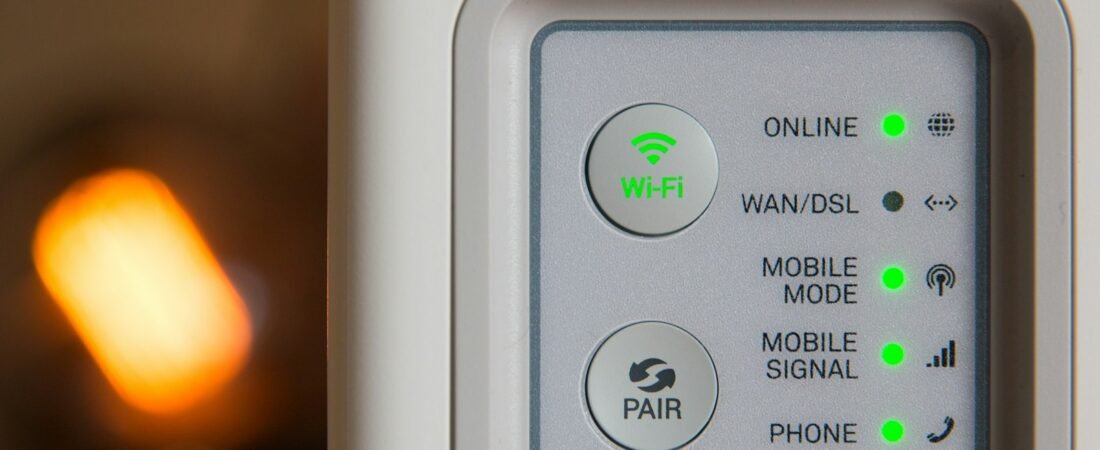 Close-up of a white home modem with green status lights for online, mobile signal and phone